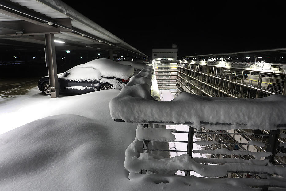 Teilweise mit Schnee bedeckt ist die oberste Etage eines Parkhauses am Münchener Flughafen. Der Flughafen München hat am Sonntag ummorgen seinen Flugbetrieb wieder aufgenommen. Wegen des heftigen Wintereinbruches in Bayern war der Flugbetrieb am Samstag vorübergehend eingestellt worden.