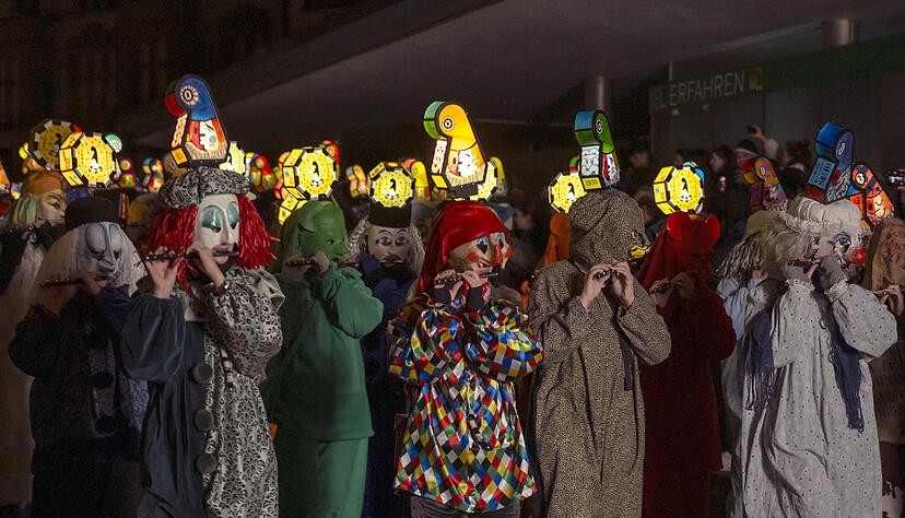 Fasnachtscliquen ziehen am Morgestraich mit Laternen durch die Stra&szlig;en in Basel.