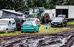 Mit Traktoren werden Fahrzeuge vom verschlammten Campinggel&auml;nde des Wacken Open Air gezogen. Foto: Axel Heimken/dpa