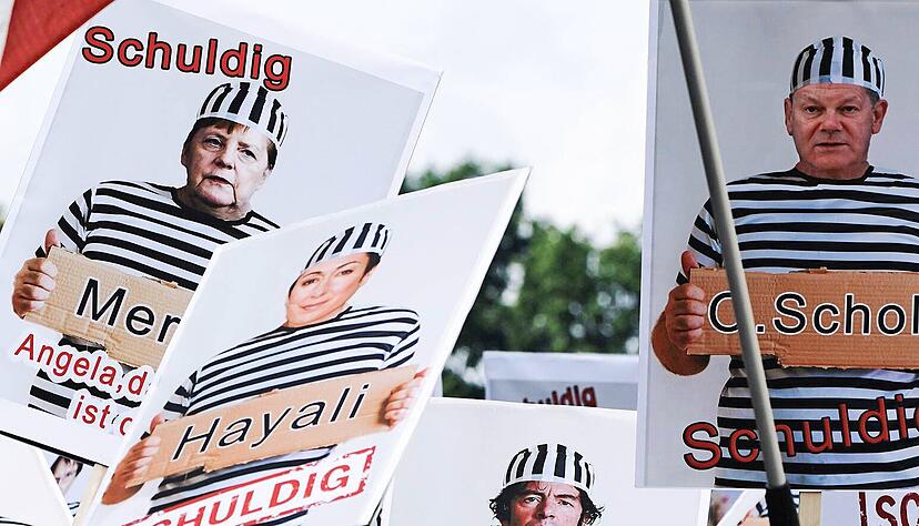 Demonstranten halten selbst gebastelte Plakate hoch.