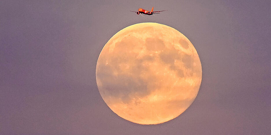 Ein Flugzeug fliegt vor dem sogenannten Supermond am frühen Abend über Leipzig. Ein Flugzeug fliegt vor dem sogenannten Supermond am frühen Abend über Leipzig.