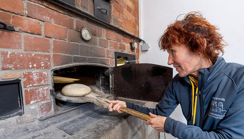Cornelia Dietrich schießt mit dem Schieber ihre neun Laibe in den rechten Ofen ein. Fünfviertel Stunden benötigen sie zum Backen. Danach wird das Mehl mit Brunnenwasser abgebürstet. Das Brot kommt noch einmal für fünf Minuten in die Hitze. Cornelia Dietrich schießt mit dem Schieber ihre neun Laibe in den rechten Ofen ein. Fünfviertel Stunden benötigen sie zum Backen. Danach wird das Mehl mit Brunnenwasser abgebürstet. Das Brot kommt noch einmal für fünf Minuten in die Hitze.