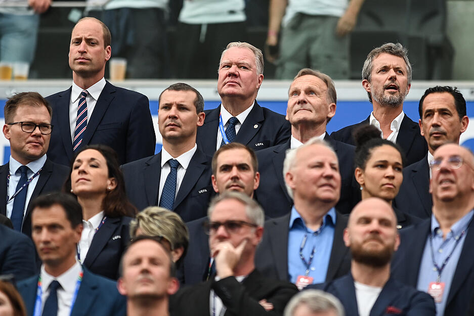 Auf der Tribüne in Frankfurt sind einige Promis neben dem royalen Besuch zu sehen.
