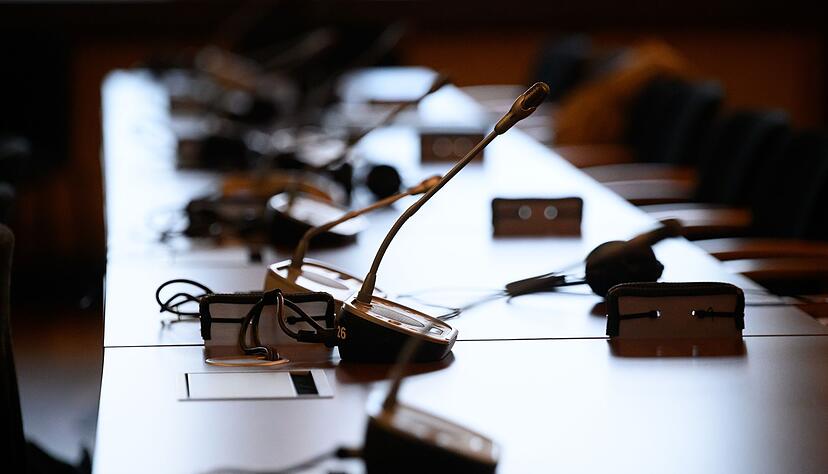 Mikrofone und Kopfhörer auf einem Tisch in einem Gerichtssaal. Mikrofone und Kopfhörer auf einem Tisch in einem Gerichtssaal.