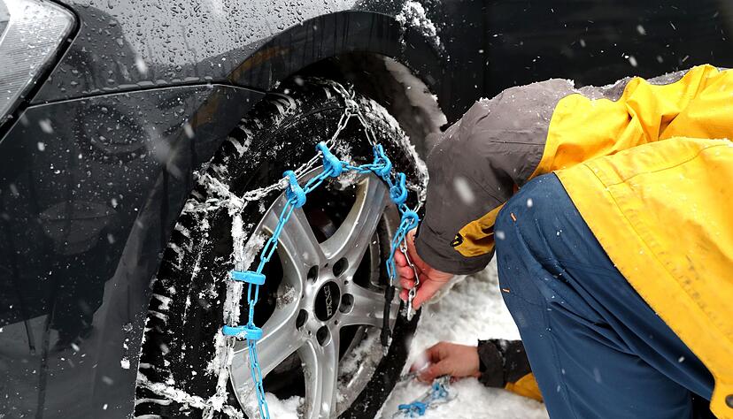 Mit ge&uuml;bter Hand: Das Anlegen von Schneeketten &uuml;ben Autofahrer besser vor dem Ernstfall. Um die H&auml;nde vor K&auml;lte und kleinen Verletzungen zu sch&uuml;tzen, sollte man zudem Handschuhe nutzen.