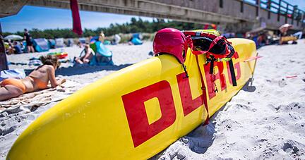 Ein Rettungsboard der DLRG Wasserrettung steht einsatzbereit neben der Seebrücke an der Ostseeküste.