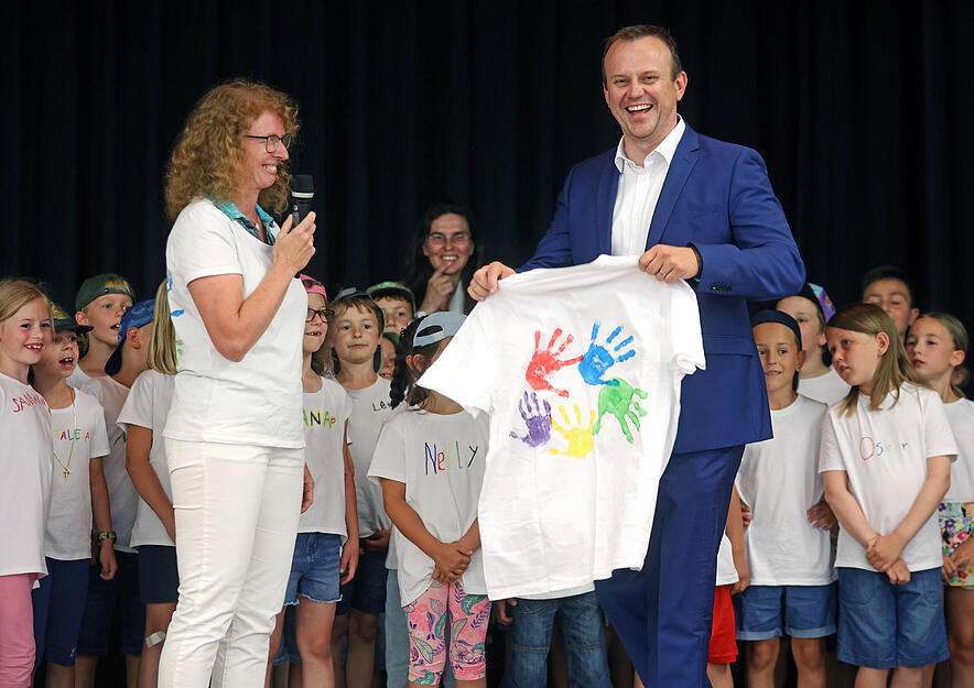 Bekommt eine Erinnerung an die Grundschule Untereisesheim: Rektorin Uta Peters und Kinder überreichen nach ihrem Auftritt dem scheidenden Bürgermeister Bernd Bordon ein buntes T-Shirt.