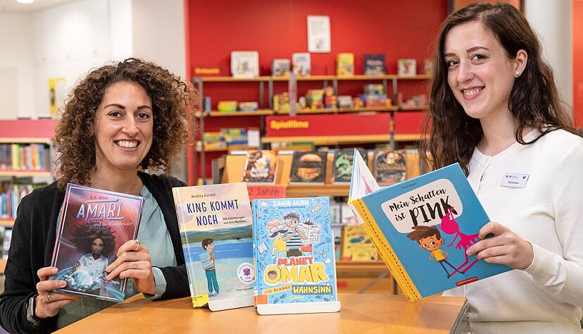 Zeigen in der Stadtbibliothek Heilbronn alternative Kinderbücher ohne rassistische Passagen: die Mitarbeiterinnen Denise Farag (li.) und Kelly Schmalz.
Foto: Andreas Veigel
