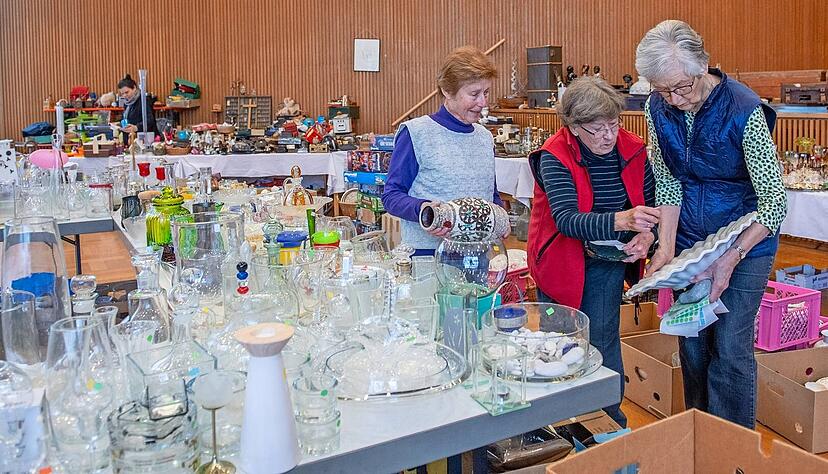 Vasen, Gef&auml;&szlig;e, Kr&uuml;ge: Adelheid Fischer, Ingrid Steinacker und Sigrid Brockhaus (von links) geh&ouml;ren zum Helferteam des CVJM-Flohmarktes und sortieren Ware auf die Tische.