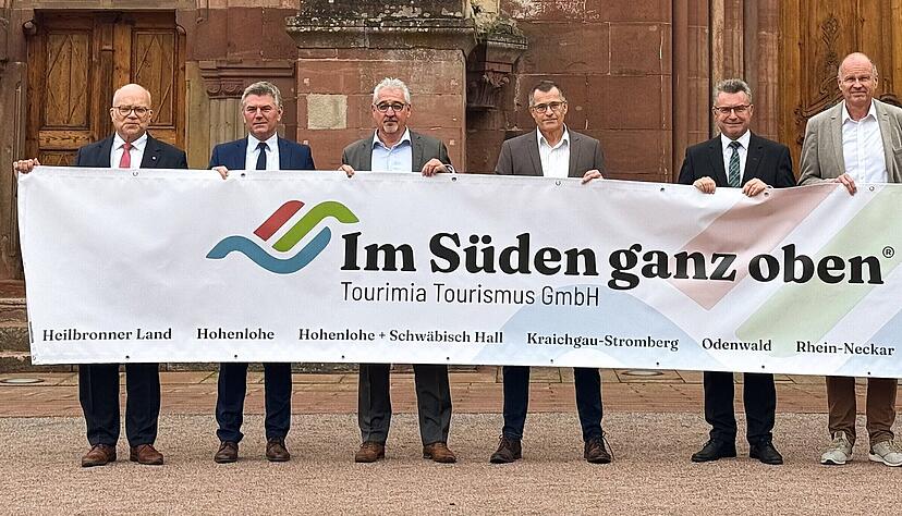 Über die neue Wort-Bild-Marke „Im Süden ganz oben“ freuen sich die Verantwortlichen der Tourimia Tourismus GmbH (von links): Landrat Norbert Heuser (Heilbronn), Landrat Ian Schölzel (Hohenlohekreis), Geschäftsführer Bernhard Mosandl, Bürgermeister Klaus Detlev Huge (Bad Schönborn), Landrat Dr. Achim Brötel (Neckar-Odenwald-Kreis), Dezernent Ulrich Bäuerlein (Rhein-Neckar-Kreis) und Landrat Christoph Schauder (Main-Tauber-Kreis). Über die neue Wort-Bild-Marke „Im Süden ganz oben“ freuen sich die Verantwortlichen der Tourimia Tourismus GmbH (von links): Landrat Norbert Heuser (Heilbronn), Landrat Ian Schölzel (Hohenlohekreis), Geschäftsführer Bernhard Mosandl, Bürgermeister Klaus Detlev Huge (Bad Schönborn), Landrat Dr. Achim Brötel (Neckar-Odenwald-Kreis), Dezernent Ulrich Bäuerlein (Rhein-Neckar-Kreis) und Landrat Christoph Schauder (Main-Tauber-Kreis).