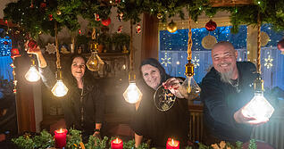 Grisu Neubeck (links) und Andy Neubeck mit Julia S. am geschm&uuml;ckten Esstisch der M&uuml;hle der Hoffnung. Julia S. freut sich, dass ihre Tochter zu Besuch kommt.