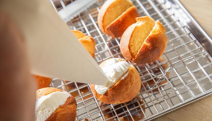 Aus Puderzucker, echter Vanille und Vollrahm wird die Creme hergestellt, die als Füllung in die herausgeschnittenen Slots der Maritozzo Romano gefüllt wird. Aus Puderzucker, echter Vanille und Vollrahm wird die Creme hergestellt, die als Füllung in die herausgeschnittenen Slots der Maritozzo Romano gefüllt wird.