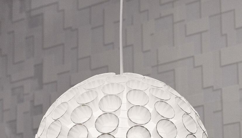 Die Pappbecher kleben an einem kugelf&ouml;rmigen Lampenschirm.