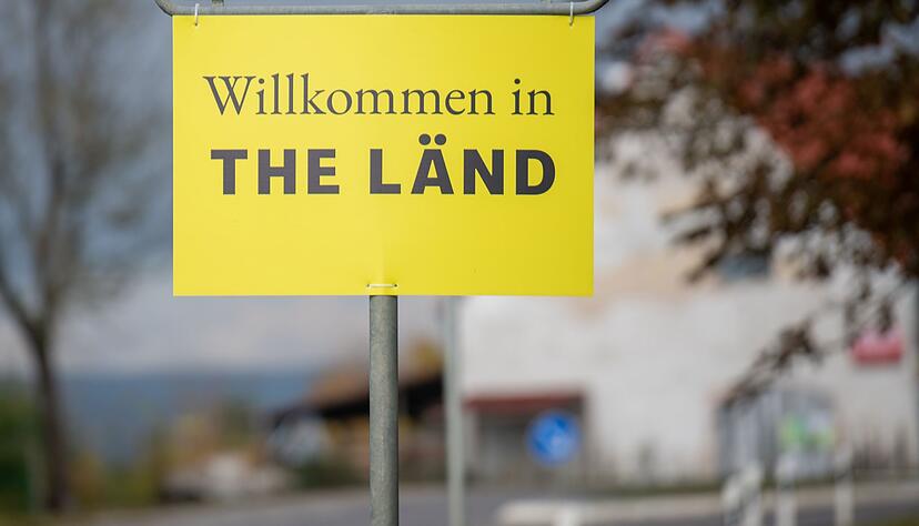 Am Ortsschild hängt ein Zusatzschild mit der Aufschrift «Willkommen in THE LÄND». Am Ortsschild hängt ein Zusatzschild mit der Aufschrift «Willkommen in THE LÄND».