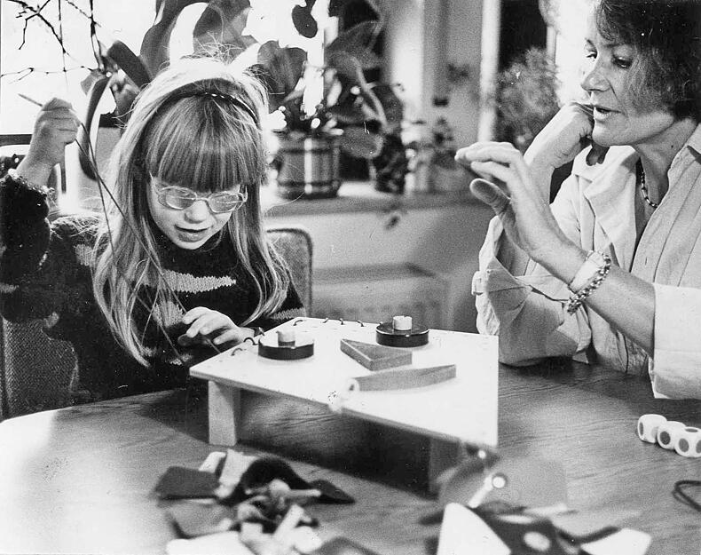 1986: Mit dem "Wunderdrachen" lassen sich viele Fertigkeiten spielerisch ein&uuml;ben: Sonderschullehrerin und f&uuml;nfj&auml;hrige Sch&uuml;lerin. Die Brille ersetzt die fehlende Augenlinse.