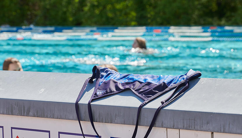 Ein Bikini liegt auf einer Mauer im Freibad. Die Jungen Liberalen wünschen sich, dass Frauen in Bädern auf ein Oberteil verzichten können.
Foto: dpa