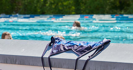 Ein Bikini liegt auf einer Mauer im Freibad. Die Jungen Liberalen wünschen sich, dass Frauen in Bädern auf ein Oberteil verzichten können.
Foto: dpa