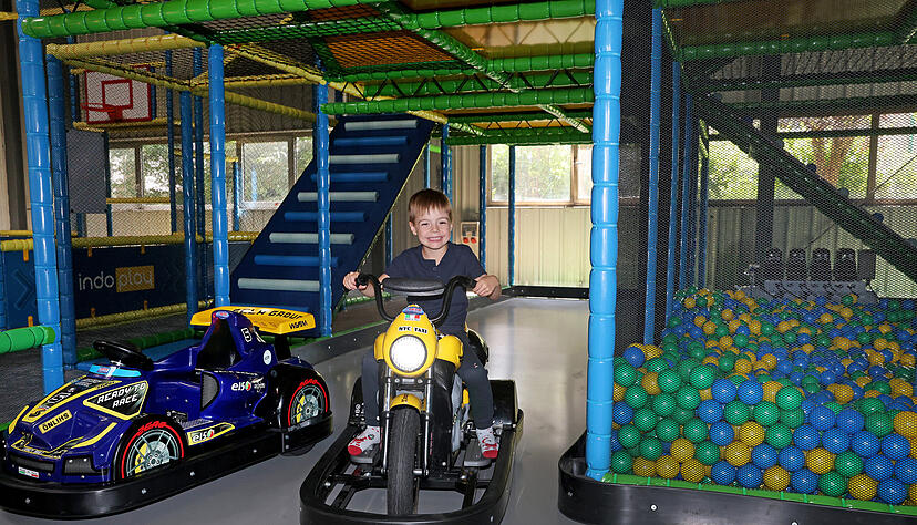 Der sechs Jahre alte Simon hat Spaß im überdachten Spielplatz. Der sechs Jahre alte Simon hat Spaß im überdachten Spielplatz.