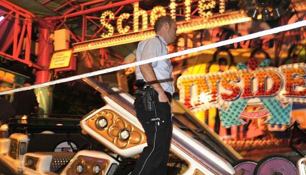 Ein Polizist sichert die Unfallstelle auf der Kirmes in Gevelsberg: Aus noch ungekl&auml;rter Ursache hatte sich eine Gondel von einem Fahrgesch&auml;ft auf gel&ouml;st. Sieben Menschen wurden verletzt. Foto: Holger Battefeld