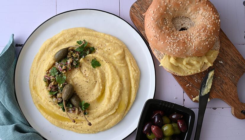 Der p&uuml;rierte Dip ist aus gelben Linsen zubereitet. Sie sind etwas weniger s&uuml;&szlig; und passen perfekt zu Kapern, Oliven und einem Sesambagel.