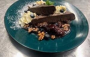 Schokoladenparfait mit Nüssen, Heidelbeeren und Glühweinzwetschgen.