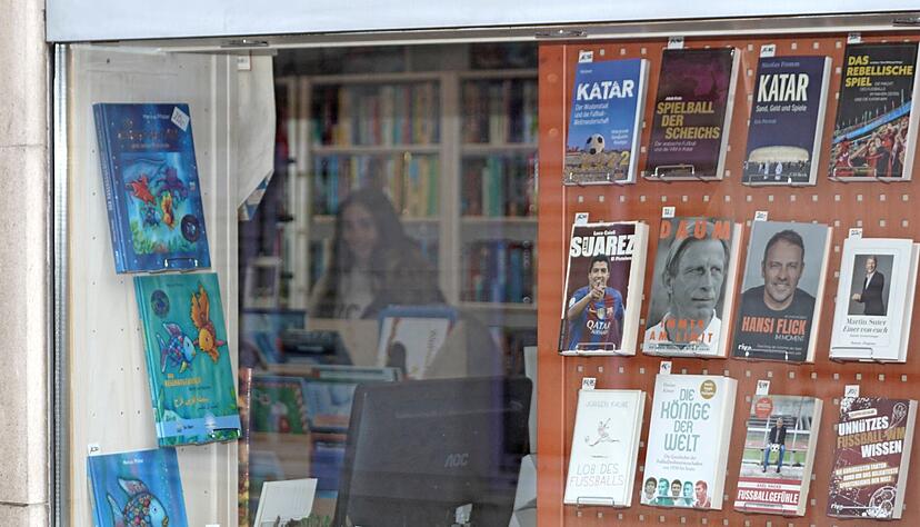Differenzierter Blick auf die Weltmeisterschaft: Das Schaufenster der B&uuml;cherwelt Heyer beleuchtet die Fu&szlig;ball-WM in Katar aus verschiedenen Winkeln. Auch hier halte sich bei Kunden das Interesse in Grenzen, sagt die Buchh&auml;ndlerin.