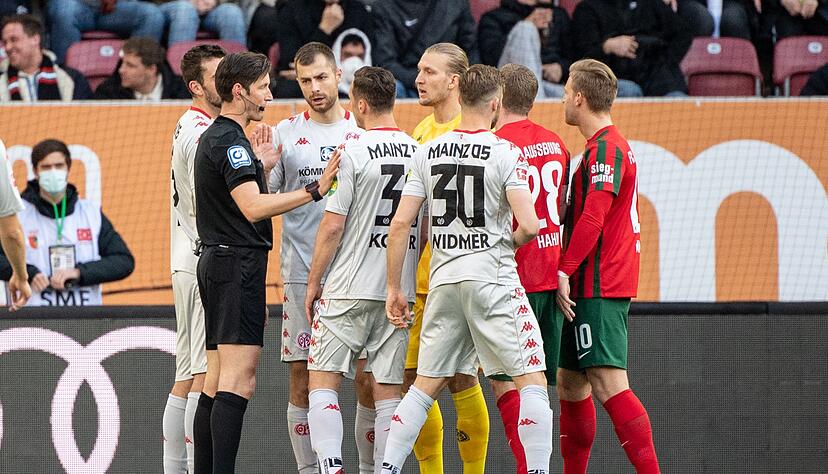 Schiedsrichter Matthias Jöllenbeck (l) spricht mit den Spielern.