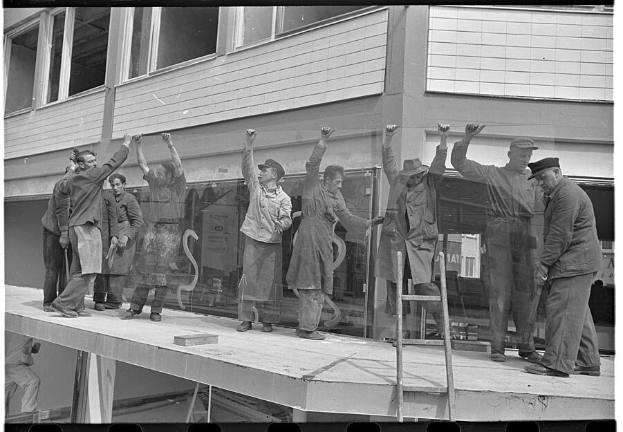 Viele Männer packen bei den Glaserarbeiten an. Aufnahme aus Mai 1957. Im November des selben Jahres wird das links benachbarte Stimme-Hochhaus eingeweiht.