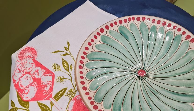 Das Tuch mit Cocktailmotiv (von Frohstoff) und der Teller in T&uuml;rkis (von Kiliim) vermitteln ein leichtes Sommergef&uuml;hl - beides gesehen bei der Trendshow auf der Frankfurter Messe Ambiente 2025.