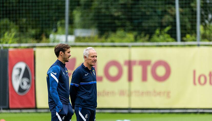 Christian Streich (r), Cheftrainer des SC Freiburg, steht auf dem Trainingsplatz und spricht mit Julian Schuster (l). Christian Streich (r), Cheftrainer des SC Freiburg, steht auf dem Trainingsplatz und spricht mit Julian Schuster (l).