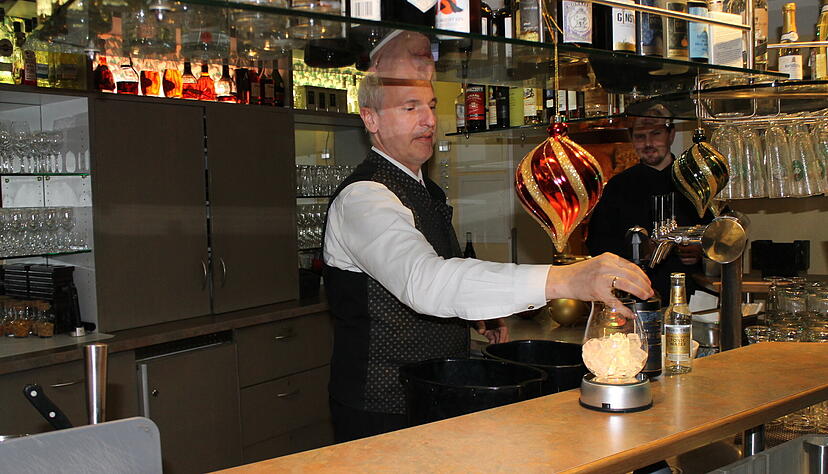 Restaurantleiter Thilo Waidmann demonstriert die Zubereitung des leuchtenden Gin Tonics in der Bar des Waldhotels Raitelberg in Wüstenrot.