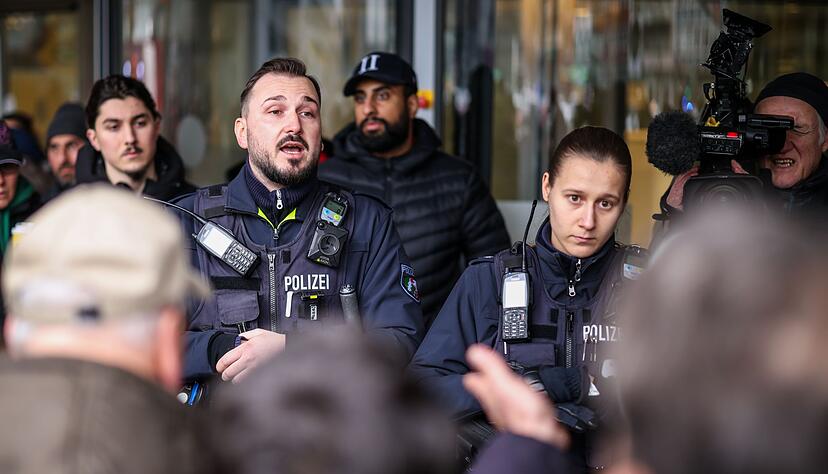Polizeibeamte sprechen mit m&ouml;glicherweise betroffenen Kunden der Sparkassenfiliale in Buer.