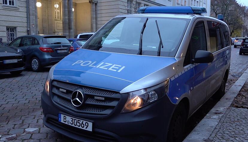 Ein Polizeiauto steht nach vermeintlichen Anschlagsandrohungen vor einer Berliner Schule.