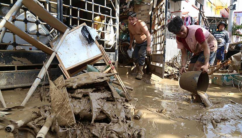 Betroffene sind dabei, sich durch den Schlamm zu arbeiten. Betroffene sind dabei, sich durch den Schlamm zu arbeiten.