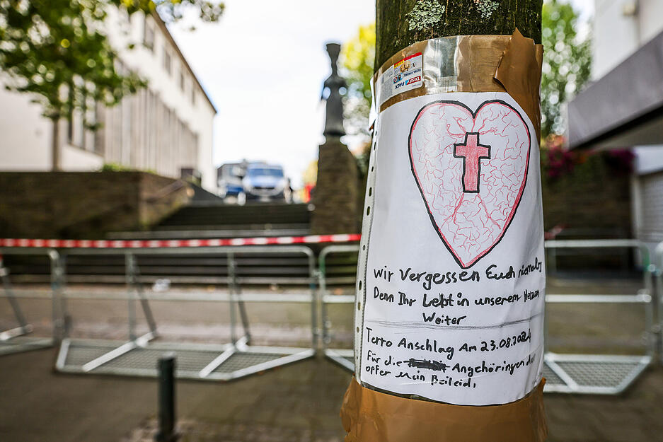 Nach der Messerattacke auf dem Solinger Stadtfest hängt ein selbstgeschriebenes Beileidsschreiben mit einem Herz und einem Kreuz an einem Baum in der Nähe des Tatorts in der Solinger Innenstadt. Bei einer Attacke auf der 650-Jahr-Feier der Stadt hat es mehrere Todesopfer und Verletzte gegeben.
