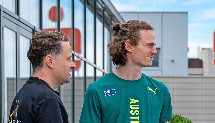 Andreas Werner (li.) vom Hochsprung-Team zeigt dem Australier Joe Baden vom Balkon der Kreissparkasse schon mal, wo er am Sonntag springt.