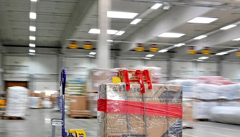 Scheinbar selbstfahrende Hubwagen werden an einer Unterflurkette durch die Halle gezogen. Die Innovation hängt an der Decke darüber. Scheinbar selbstfahrende Hubwagen werden an einer Unterflurkette durch die Halle gezogen. Die Innovation hängt an der Decke darüber.