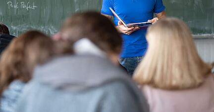 Ein Lehrer unterrichtet in einem Klassenzimmer einer Realschule.
