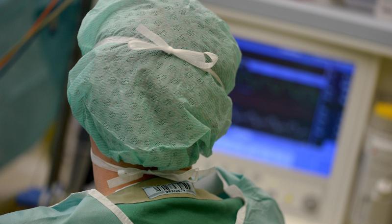 Ein Mediziner schaut während einer Operation auf einen Überwachungs-Monitor. Ein Mediziner schaut während einer Operation auf einen Überwachungs-Monitor.