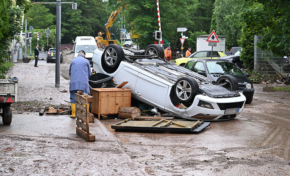 Auf einer Straße in Rudersberg liegt ein durch ein Hochwasser umgestürtztes Auto auf dem Dach. Auf einer Straße in Rudersberg liegt ein durch ein Hochwasser umgestürtztes Auto auf dem Dach.