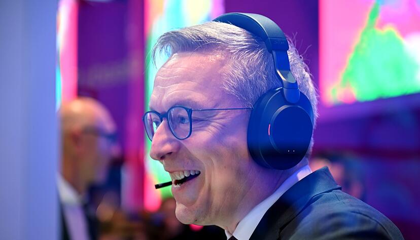 Bundesdigitalminister Karsten Wildberger bei einem Testgespräch, bei dem der KI-Assistent eingebunden war. Im Hintergrund steht Telekom-Chef Tim Höttges. Bundesdigitalminister Karsten Wildberger bei einem Testgespräch, bei dem der KI-Assistent eingebunden war. Im Hintergrund steht Telekom-Chef Tim Höttges.