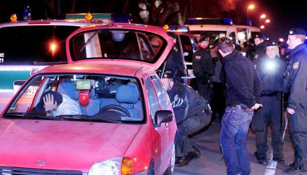 Polizeibeamte kontrollieren in Dortmund nach Auseinandersetzungen unter Fu&szlig;ballfans ein Auto. Foto: Frank Bock