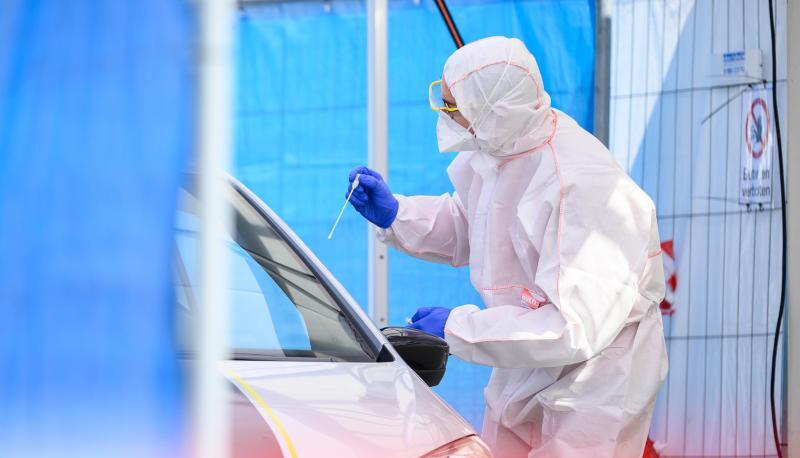 Ein Mitarbeiter führt in einem Abstrichzentrum einen Corona-Test durch. Ein Mitarbeiter führt in einem Abstrichzentrum einen Corona-Test durch.