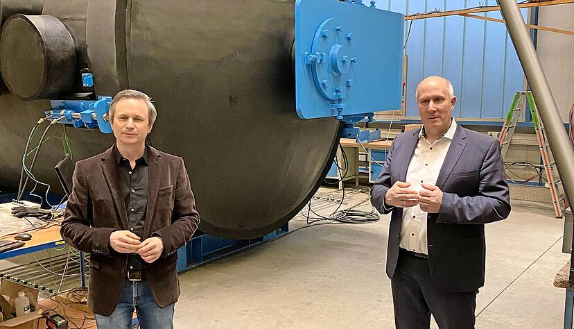 Unternehmer Hans Halmosi (links) und Wirtschaftsf&ouml;rderer Patrick Dufour vor der Klimakammer, die f&uuml;r Lkw-Wasserstofftanks konzipiert wurde.
Foto: WFG
