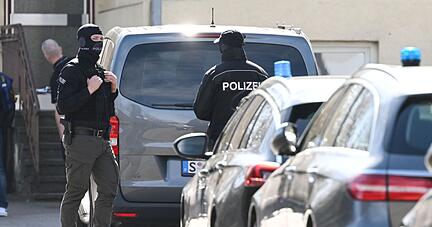 Einsatzkräfte stehen an Einsatzfahrzeugen.