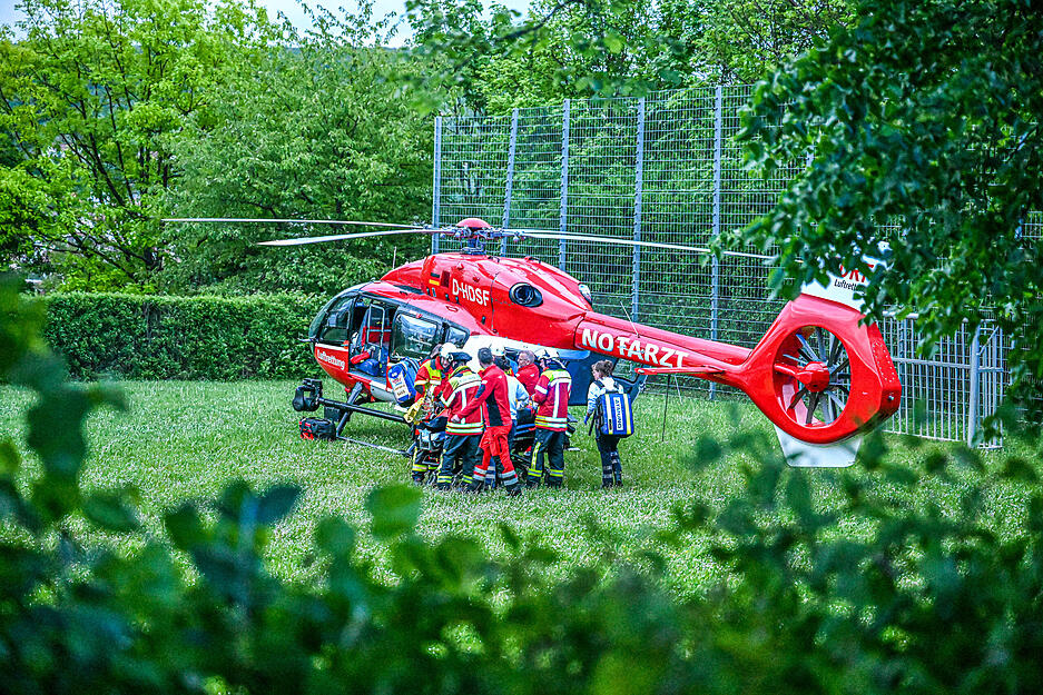 Einsatzkräfte bringen ein verletztes Kind zu dem Rettungshubschrauber in der Nähe einer alten Sporthalle. Einsatzkräfte bringen ein verletztes Kind zu dem Rettungshubschrauber in der Nähe einer alten Sporthalle.