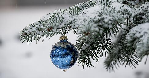An einem Nadelbaum h&auml;ngt blauer Weihnachtsbaumschmuck. Die Wetterprognose f&uuml;r die Festtage ist noch unsicher.