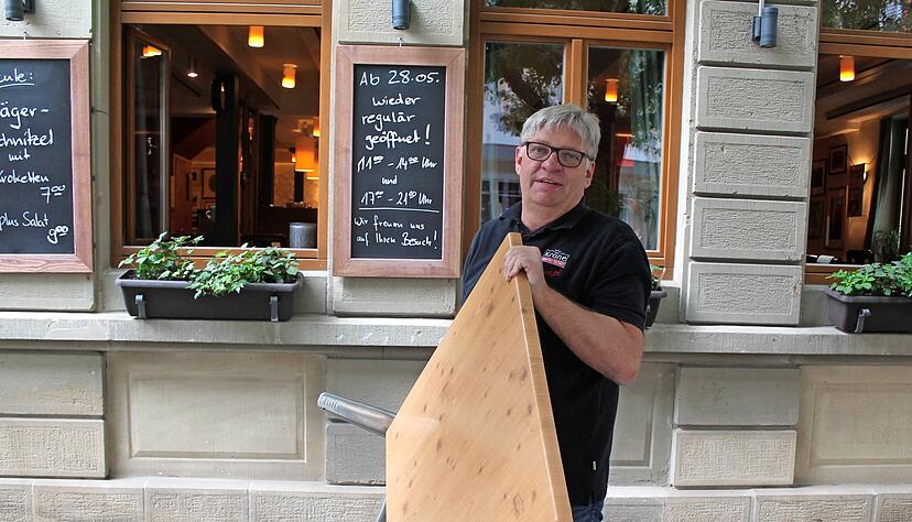 "Krone"-Wirt Klaus Frey packt mit an, um alles vorzubereiten. Der Brauerei-Gasthof in der Öhringer Marktstraße durfte sieben Monate nur Essen zum Mitnehmen anbieten. Ab heute können drinnen wie draußen Gäste empfangen werden. 
Foto: Christoph Kraft