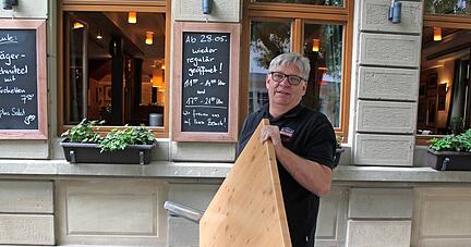 "Krone"-Wirt Klaus Frey packt mit an, um alles vorzubereiten. Der Brauerei-Gasthof in der Öhringer Marktstraße durfte sieben Monate nur Essen zum Mitnehmen anbieten. Ab heute können drinnen wie draußen Gäste empfangen werden. 
Foto: Christoph Kraft