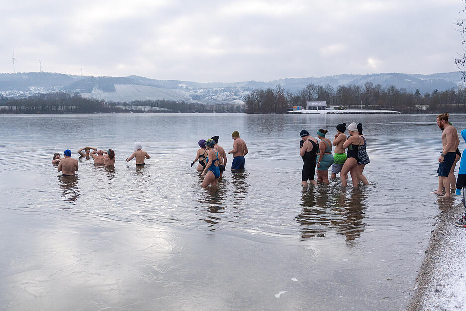 Langsam watet die Gruppe ins zwei Grad kalte Wasser. Manche erprobte Eisbader tauchen bis zu den Schultern ein.